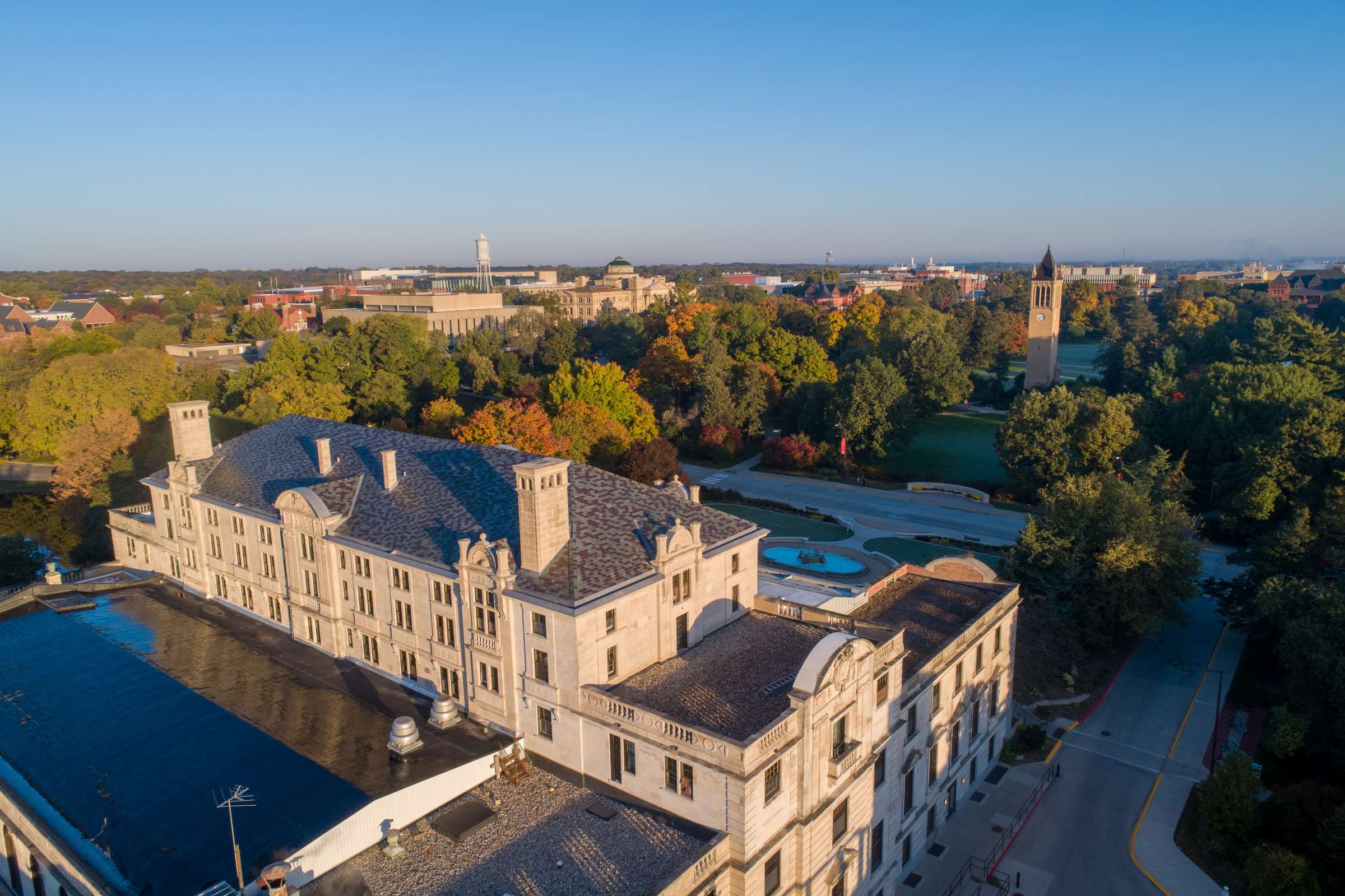 A drone photograph of Iowa State's campus. In view is the Memorial Union, Campanile, and the many trees on campus